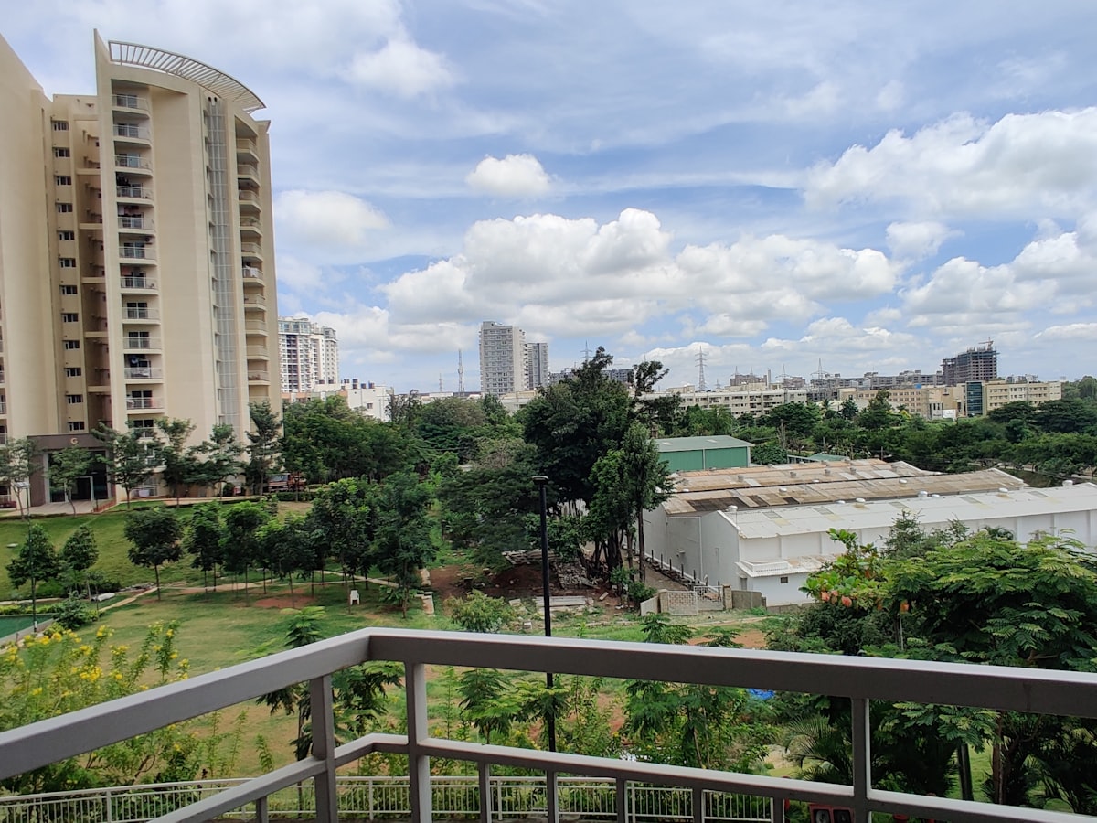 The view from an apartment balcony over a landscaped garden towards residential towers