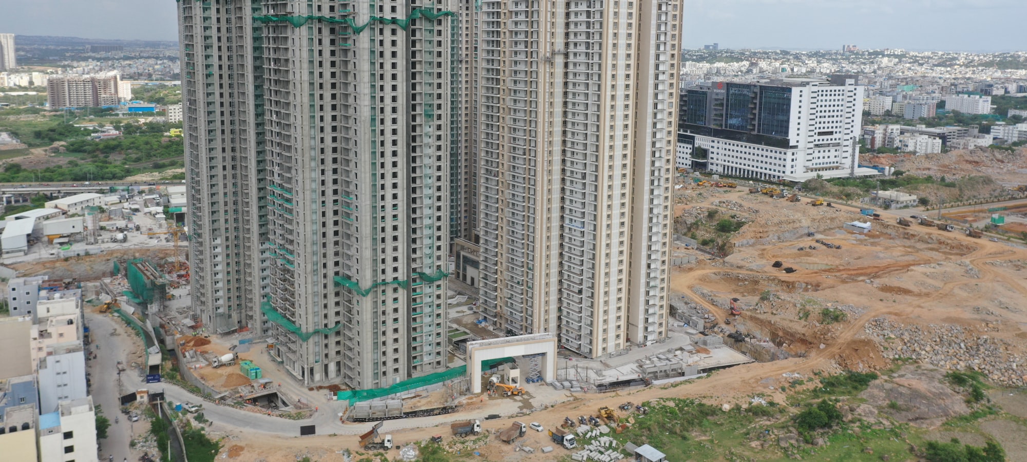 An aerial view of residential towers under construction on the edge of a growing Indian city